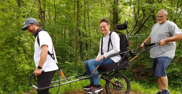 Deux marcheurs avec une joëlette