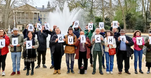 Chaque personne tient une lettre du message "Bxl pour les guichets"