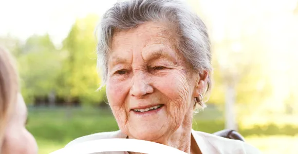 une personne âgée, accompagnée, profite d'un moment de détente