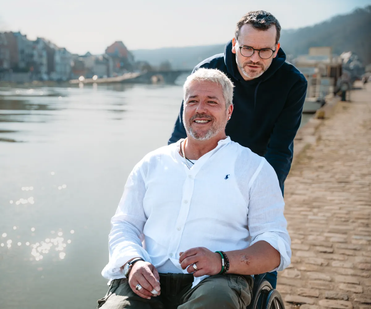 Personne en chaise roulante poussée par une autre personne