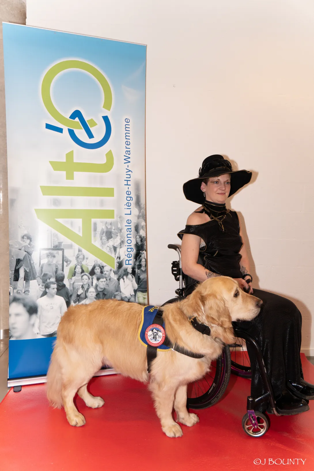Magali pose avec son chien sur un tapis rouge